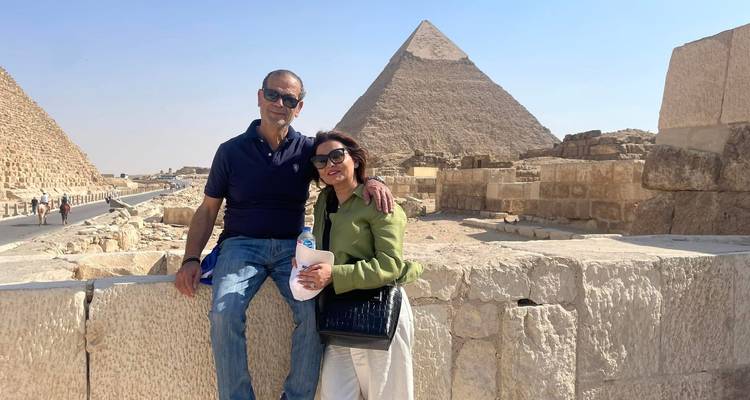 Paar posiert vor Pyramiden an einem sonnigen Tag.