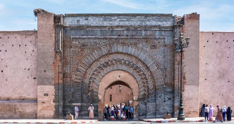 Group of tourists at a historical arched gate.