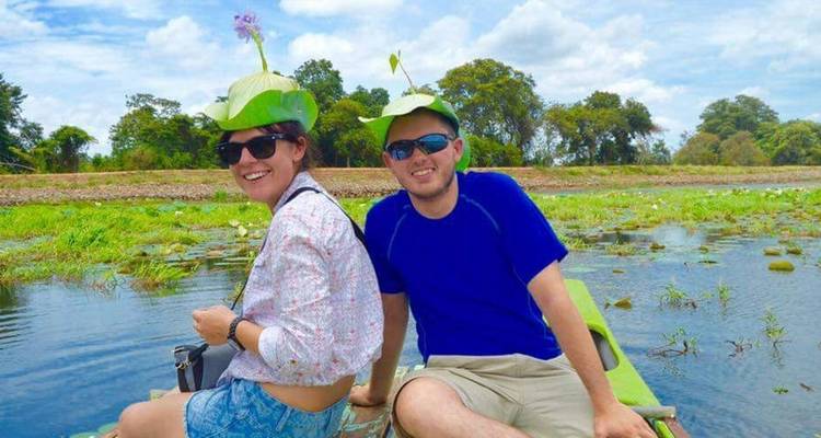 Zwei Personen mit provisorischen Hüten bei einer Bootsfahrt.