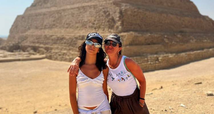 Mère et fille devant une pyramide à degrés par une journée ensoleillée.