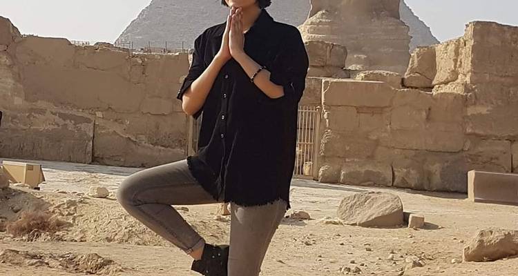Persoon die poseert in een yogahouding bij de Sfinx.