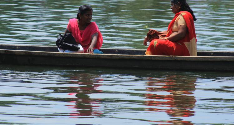 Deux femmes assises dans un bateau sur une eau calme.