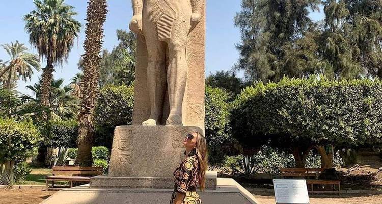 Frau, die vor einer altägyptischen Statue steht.