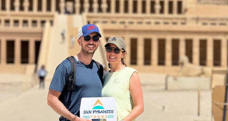 Couple holding a sign in an ancient temple complex.