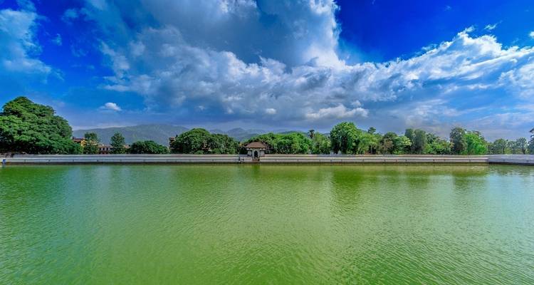 Calm body of water with greenery and blue skies.