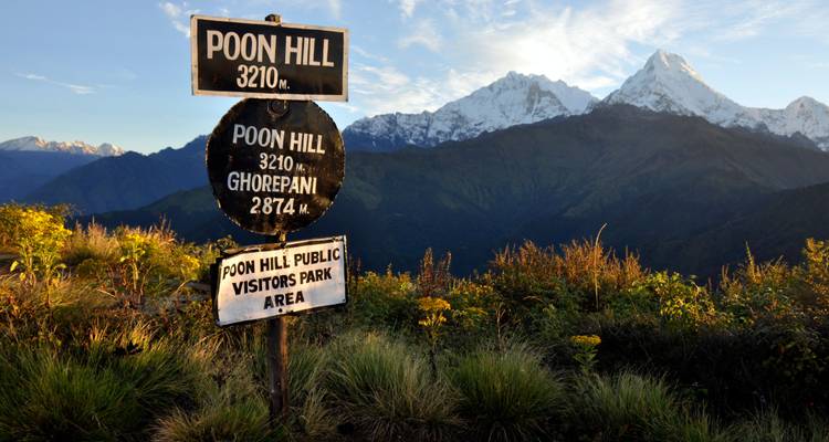 Uitzicht op bergen met gebedsvlaggen op de voorgrond.