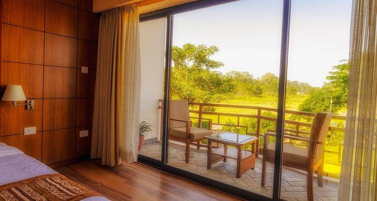Hotel room with balcony and outdoor furniture.