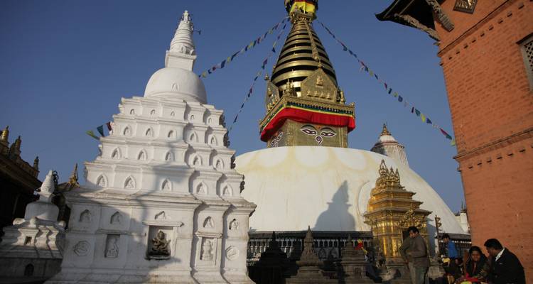 Estupa de Swayambhunath con gente y banderas de oración.
