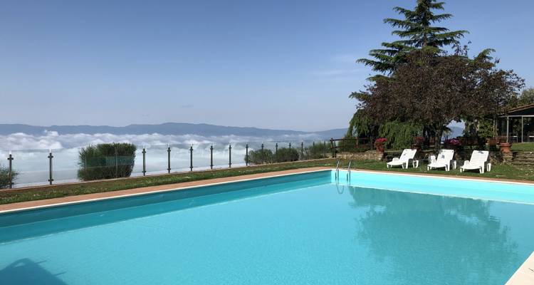 Freibad mit Liegestühlen und Bergblick.