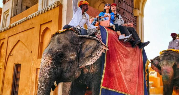 Tourists riding an elephant at an Indian monument.