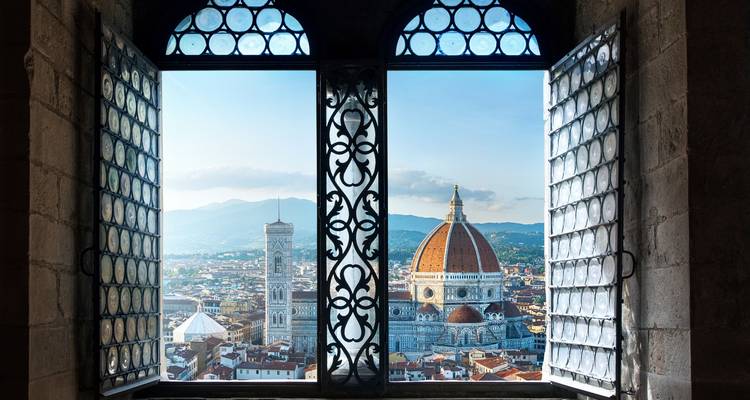 Panoramisch uitzicht op de Kathedraal van Florence en daken van de stad ingelijst door sierlijke open ramen.