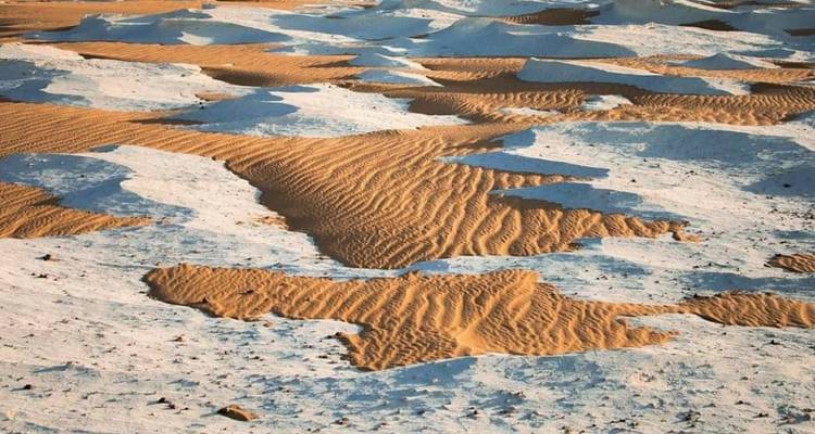 Woestijnlandschap met unieke zand- en rotspatronen.