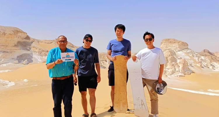 Groupe avec équipement de surf sur sable dans un environnement désertique.