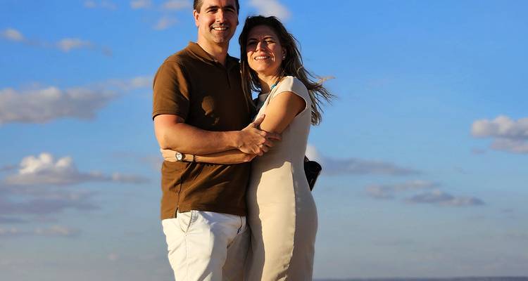 Couple embracing under a blue sky.