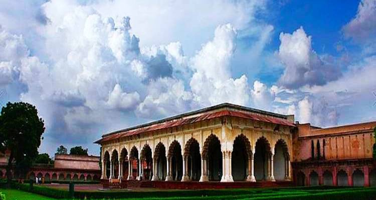 Een historisch gebouw met een bewolkte hemel.