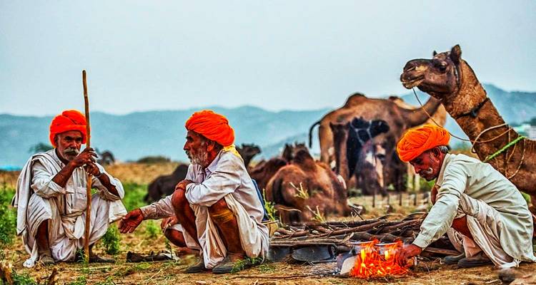 Mannen in traditionele kledij met kamelen.