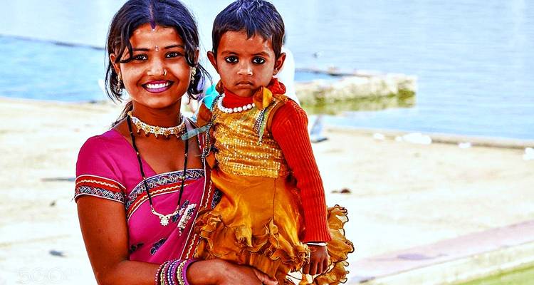 Moeder en kind glimlachend in kleurrijke kleding.