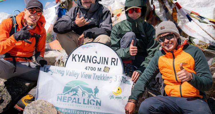Des randonneurs à Kyangjin Ri, posant avec un panneau.