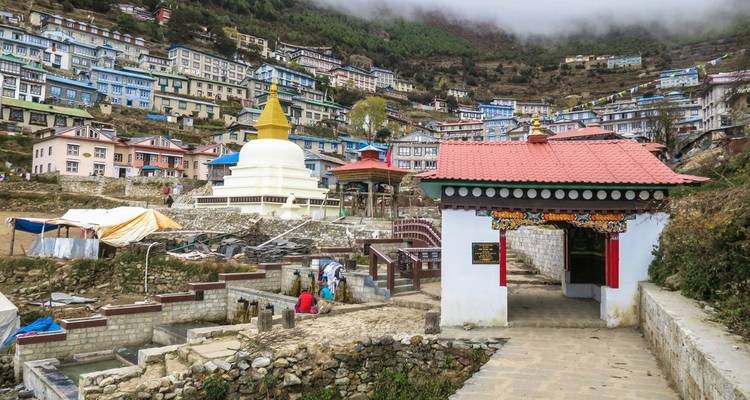 Colorful village with stupa in a mountain valley.