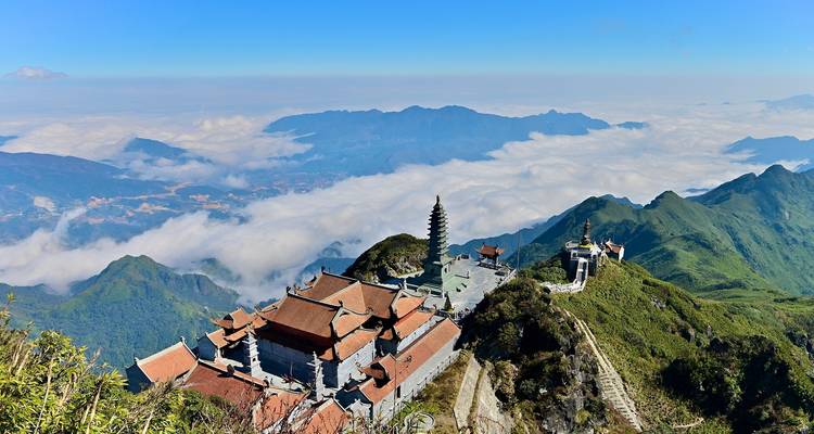 Complejo de templos en la cima de la montaña con vista sobre las nubes.