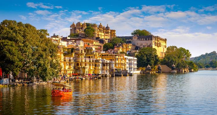 Colorful buildings along a lakeside with a boat.
