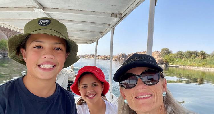 Drei Personen auf einem Boot mit einer malerischen Kulisse.