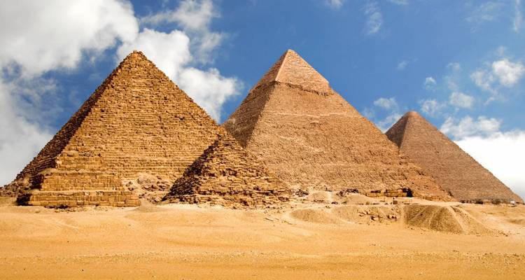 Tres pirámides que están una al lado de la otra en una zona desértica.