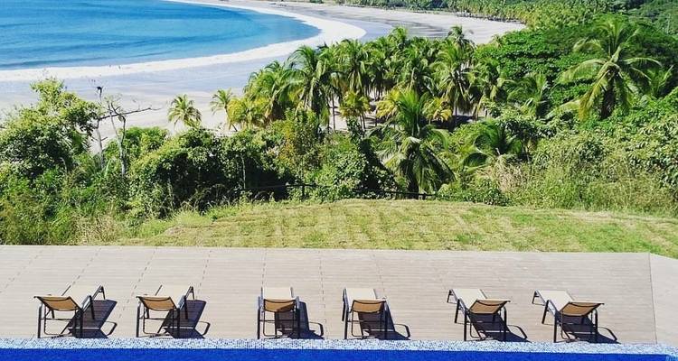 Vue sur une plage tropicale depuis un cadre luxueux au bord de la piscine.