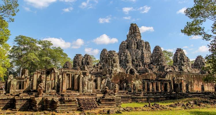 Ancient temple ruins with trees and clear sky.