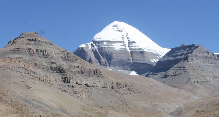 Sneeuwbedekte berg onder een heldere blauwe hemel.