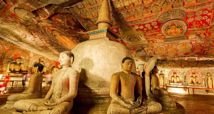 Wunderschön geschmückter Tempelinnenraum mit Buddha-Statuen und bemalter Decke.