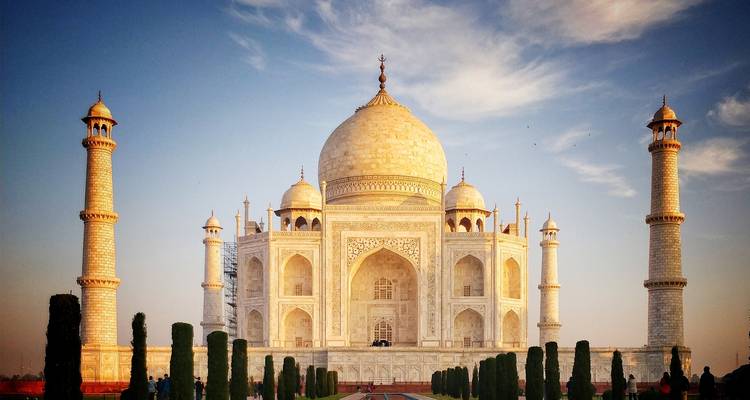 Vista frontal del Taj Mahal al amanecer con cielos despejados.