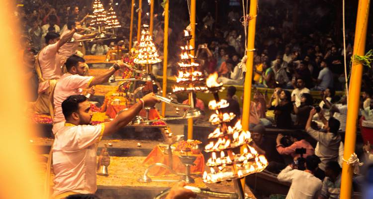 Ceremonial ritual with people holding lamps in a crowd.