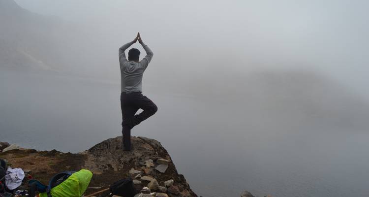 Person beim Yoga an einem nebligen See.