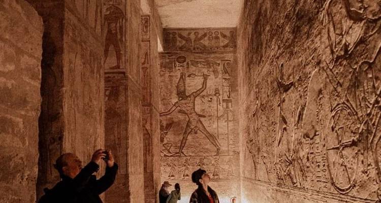 People observe detailed ancient wall carvings inside a temple.

**Dutch translation:**
Mensen bekijken gedetailleerde oude muurreliëfs in een tempel.