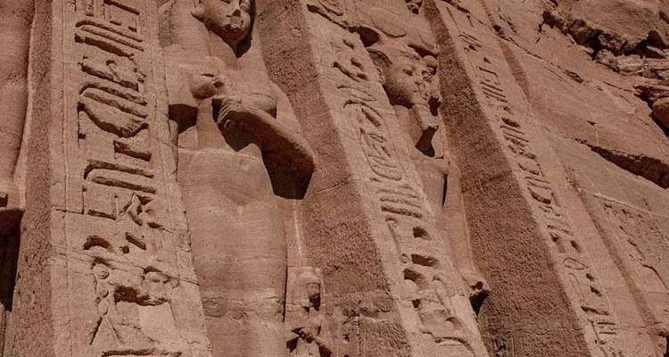 Gedetailleerde gravures van farao's op het rotsoppervlak van een tempelgevel.