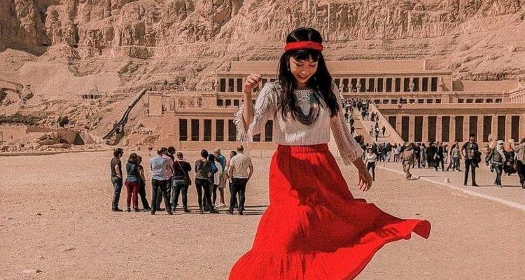 Een vrouw die vreugdevol danst op het voorplein van de Tempel van Hatsjepsoet.