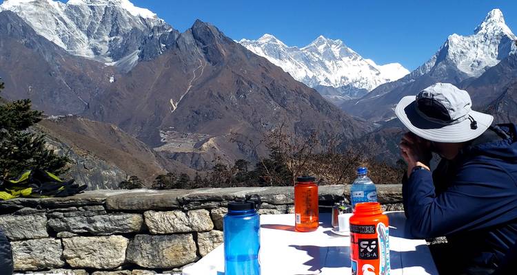 Person sitting at a table with a mountain view.
