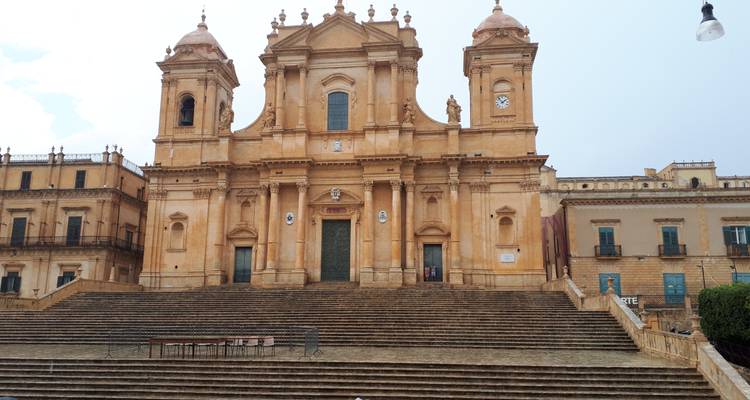 Große Kathedrale mit großartiger Treppe und bewölktem Himmel.