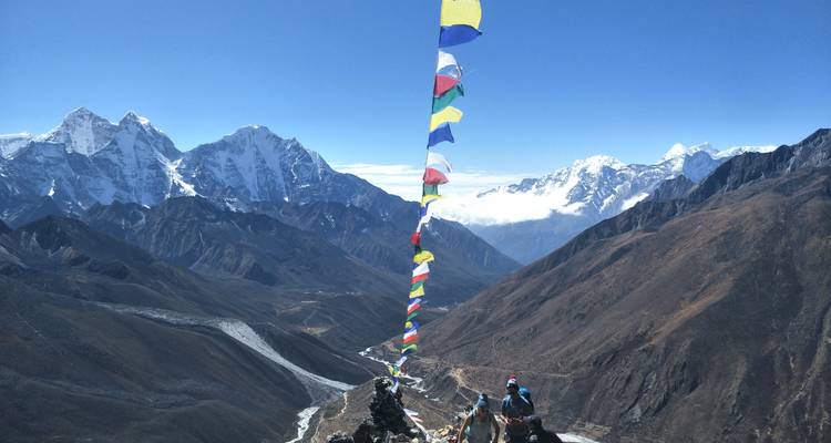 Berglandschap met gebedsvlaggen en trekkers.