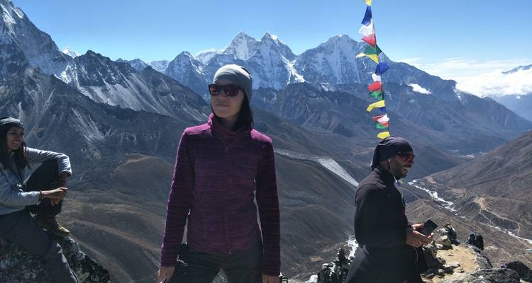 Wandelaars op een bergpad met gebedsvlaggen.