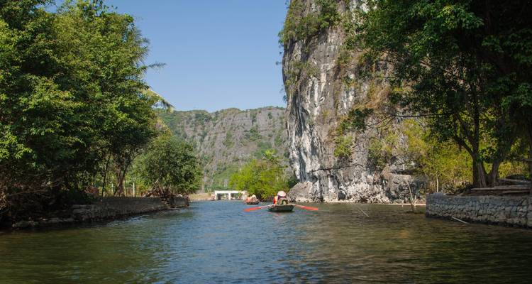 A serene river passage with high cliffs and forested banks.