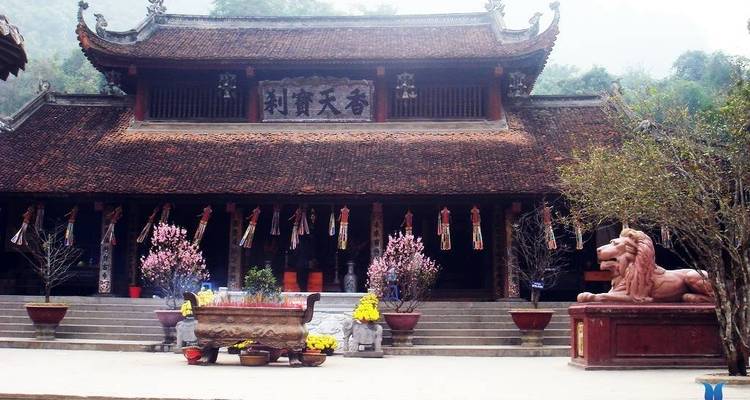 Traditionele Aziatische tempel met sierlijk dakontwerp en een leeuwenbeeld.