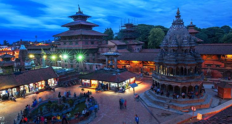 Historischer Platz in der Abenddämmerung mit beleuchteten Tempeln in Kathmandu.