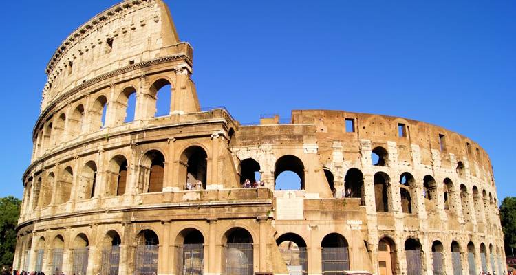 The Colosseum in Rome under a clear blue sky.