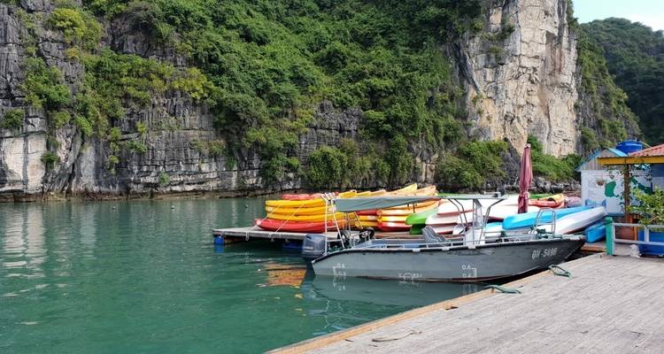 Kajaks op een steiger in Halong Bay met rotsformaties.