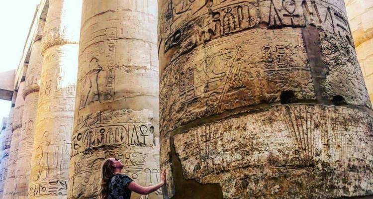 Mujer tocando columna del antiguo Egipto con jeroglíficos