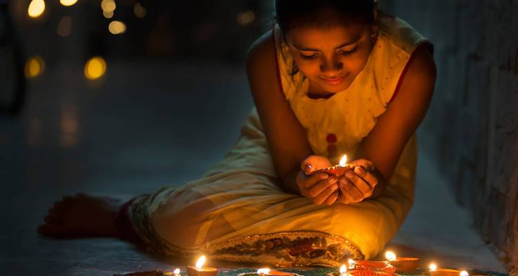 Niña encendiendo velas, celebrando un festival.