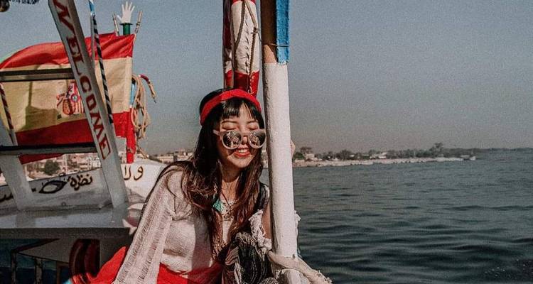 Frau auf einem Boot lächelnd mit dem Fluss im Hintergrund