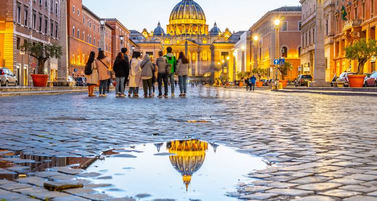 St. Peter's Basilica with a group of people reflected in a puddle
